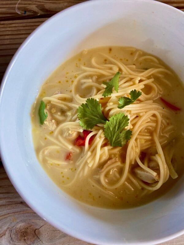 coconut curry soup with chicken and noodles in bowl close